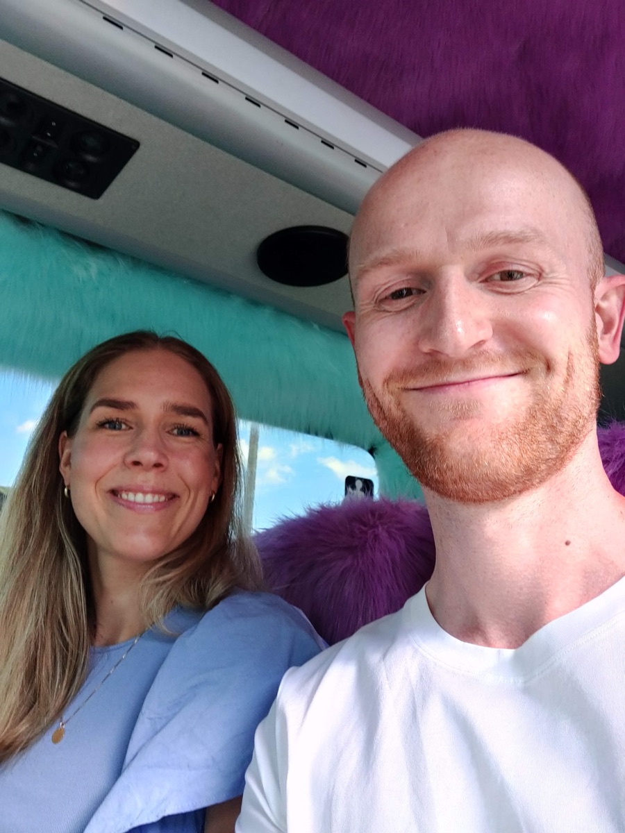 Malene og Steffen smiler i en buss med fargerik pels i taket